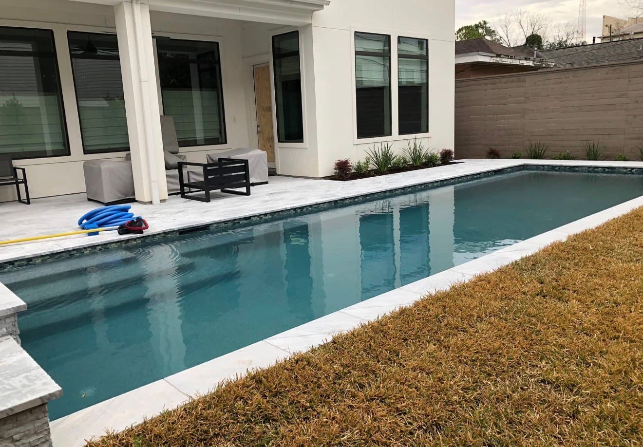 Luxury pool with marble deck, glass tile waterline, and elegant raised spa — Houston, TX