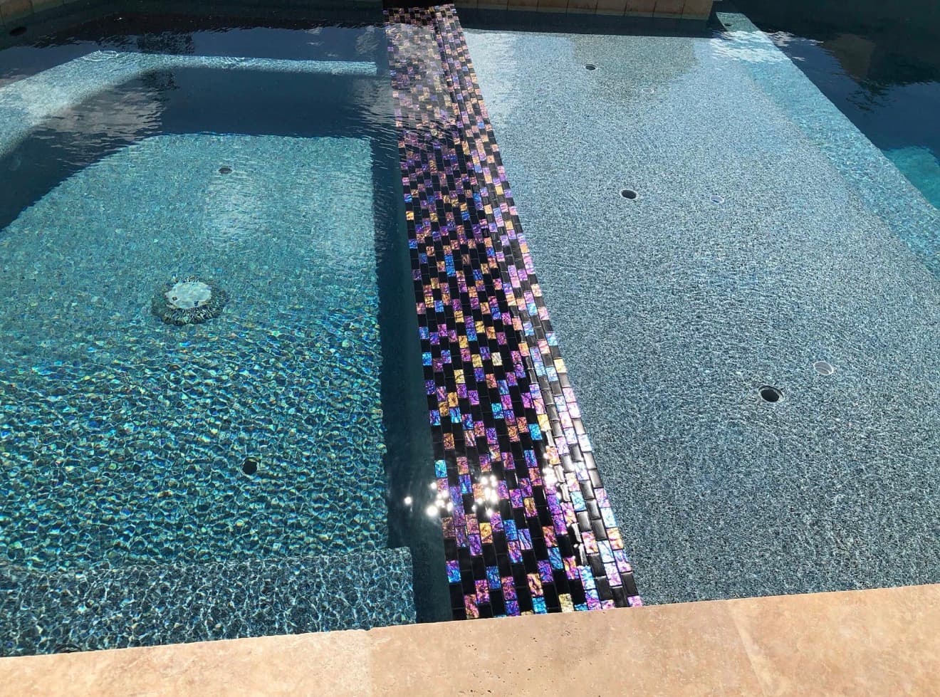 Rectangular lap pool with a fresh dark interior finish, grey granite coping and a patterned tile wall — Houston, TX
